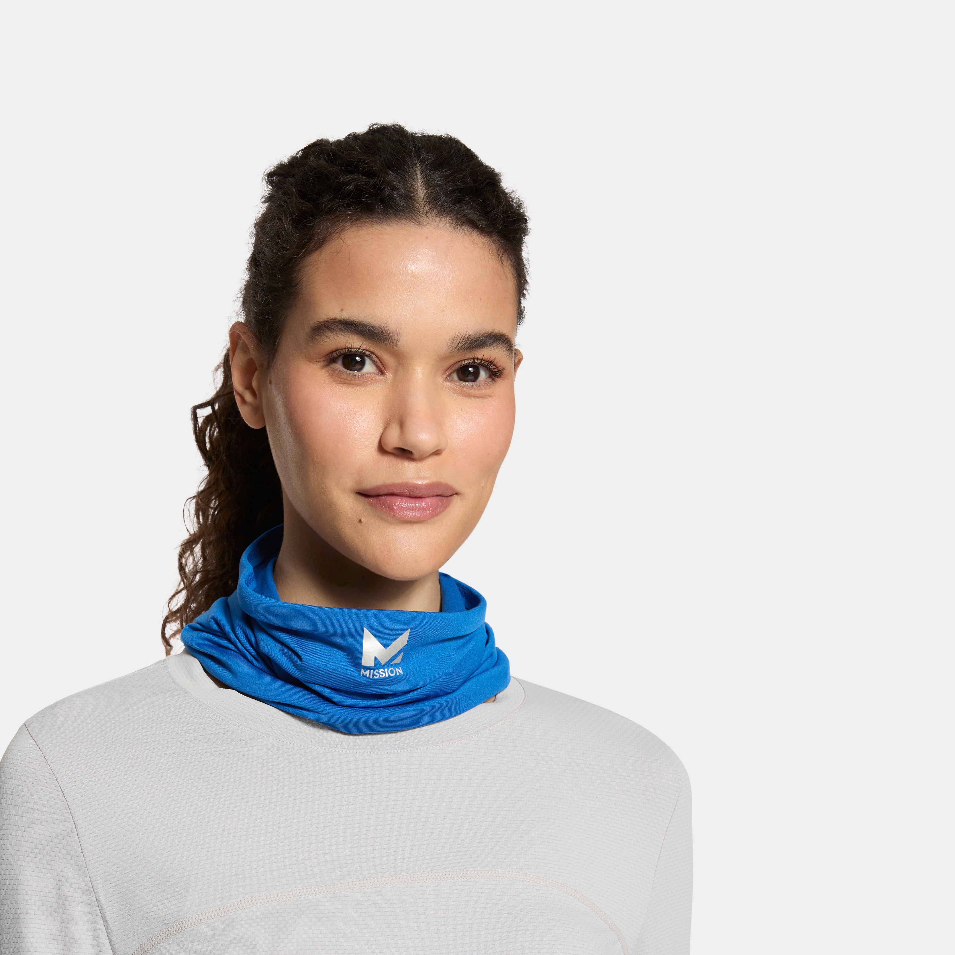 Woman wearing a blue neck gaiter with a logo on a white background