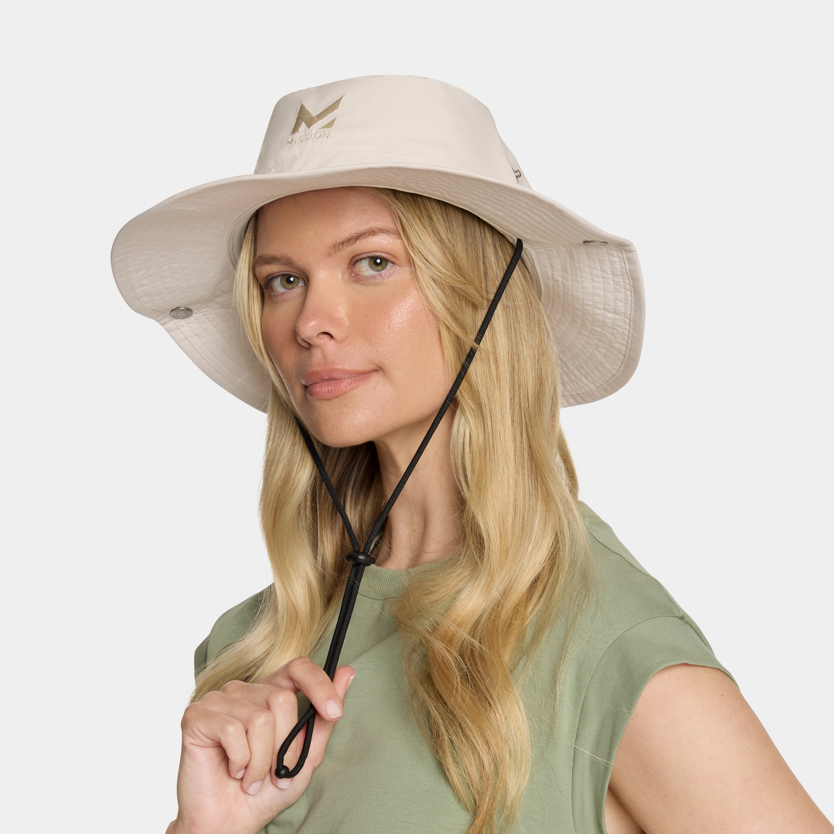 Woman wearing a beige bucket hat with a brand logo on a white background
