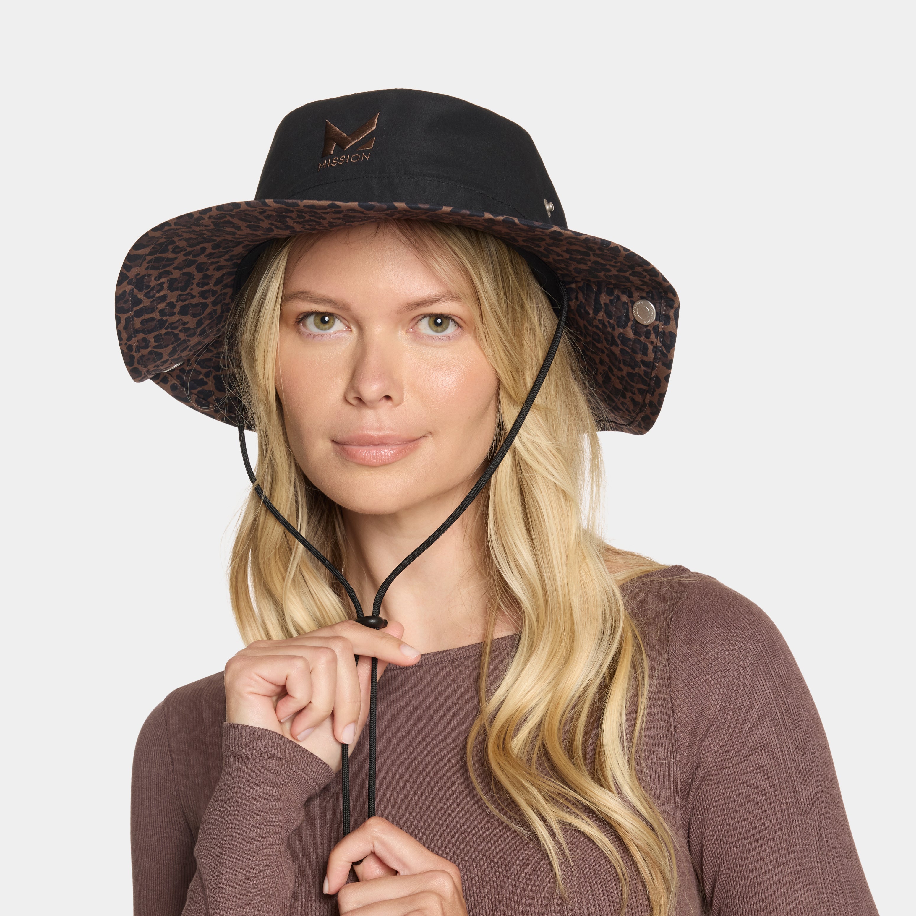 Woman wearing a black and leopard print hat on a white background