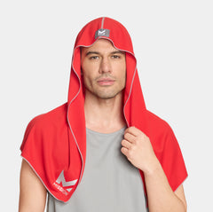 Man wearing a red hooded towel with a logo on a light gray background