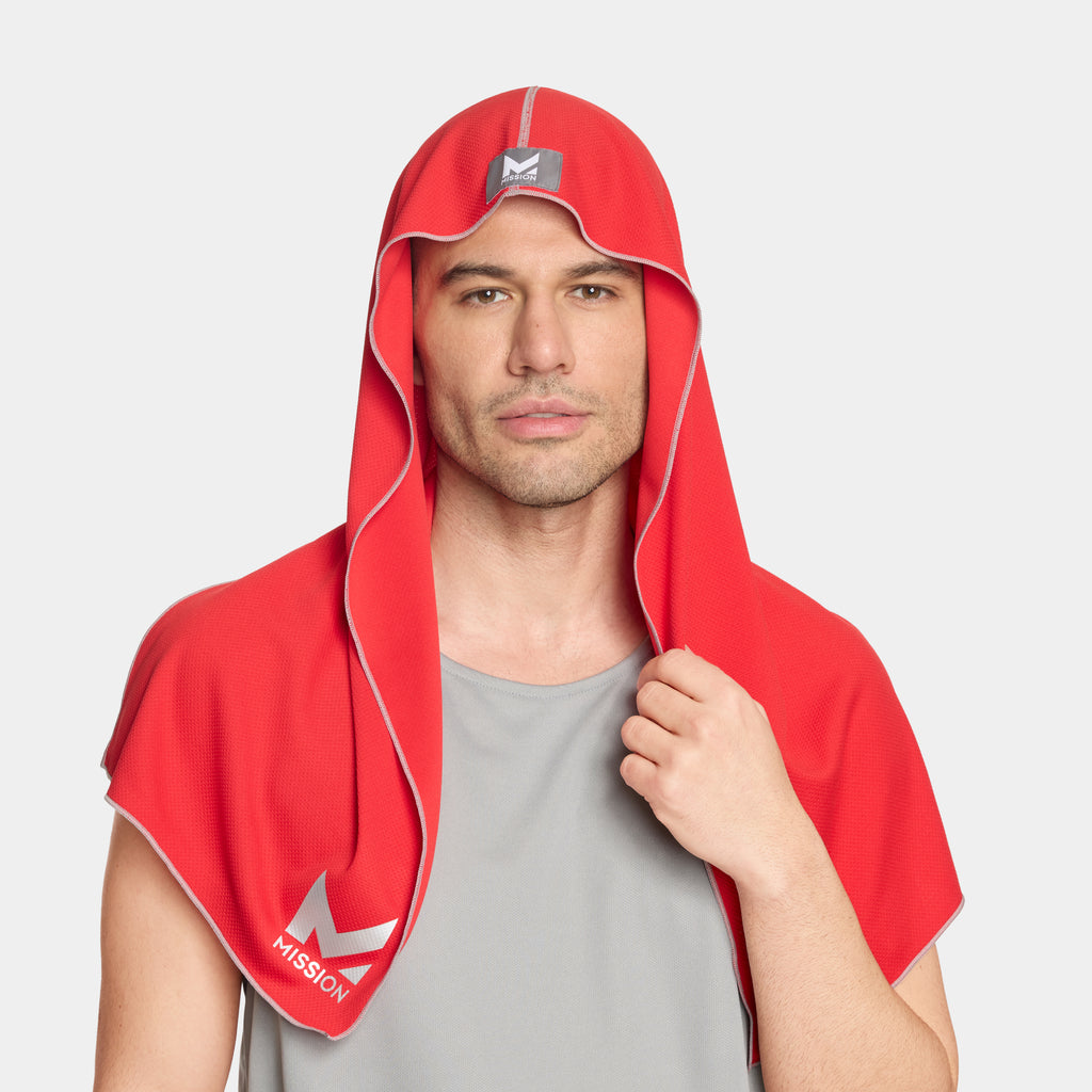 Man wearing a red hooded towel with a logo on a light gray background