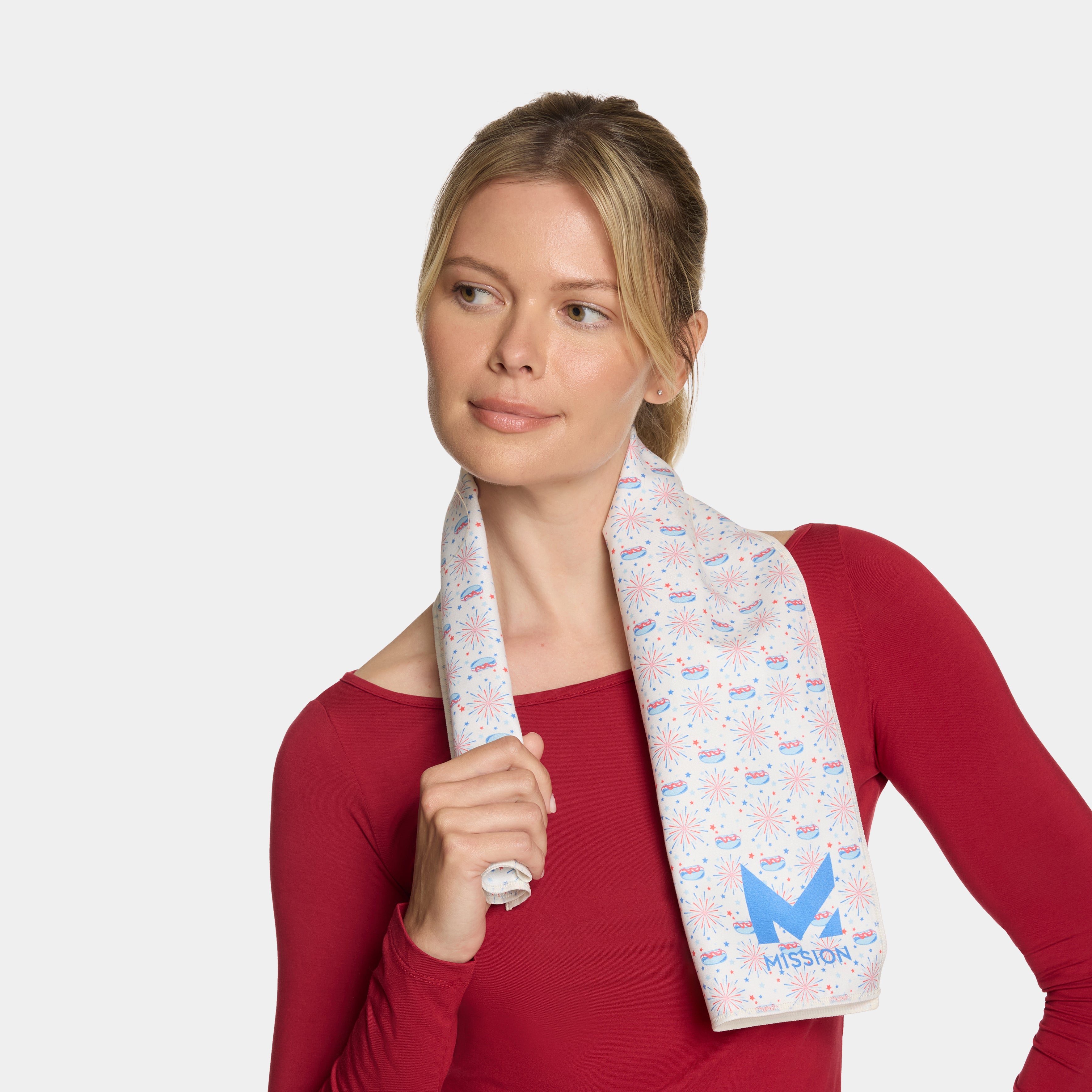Woman wearing a red shirt with a patterned towel draped over her shoulder on a white background