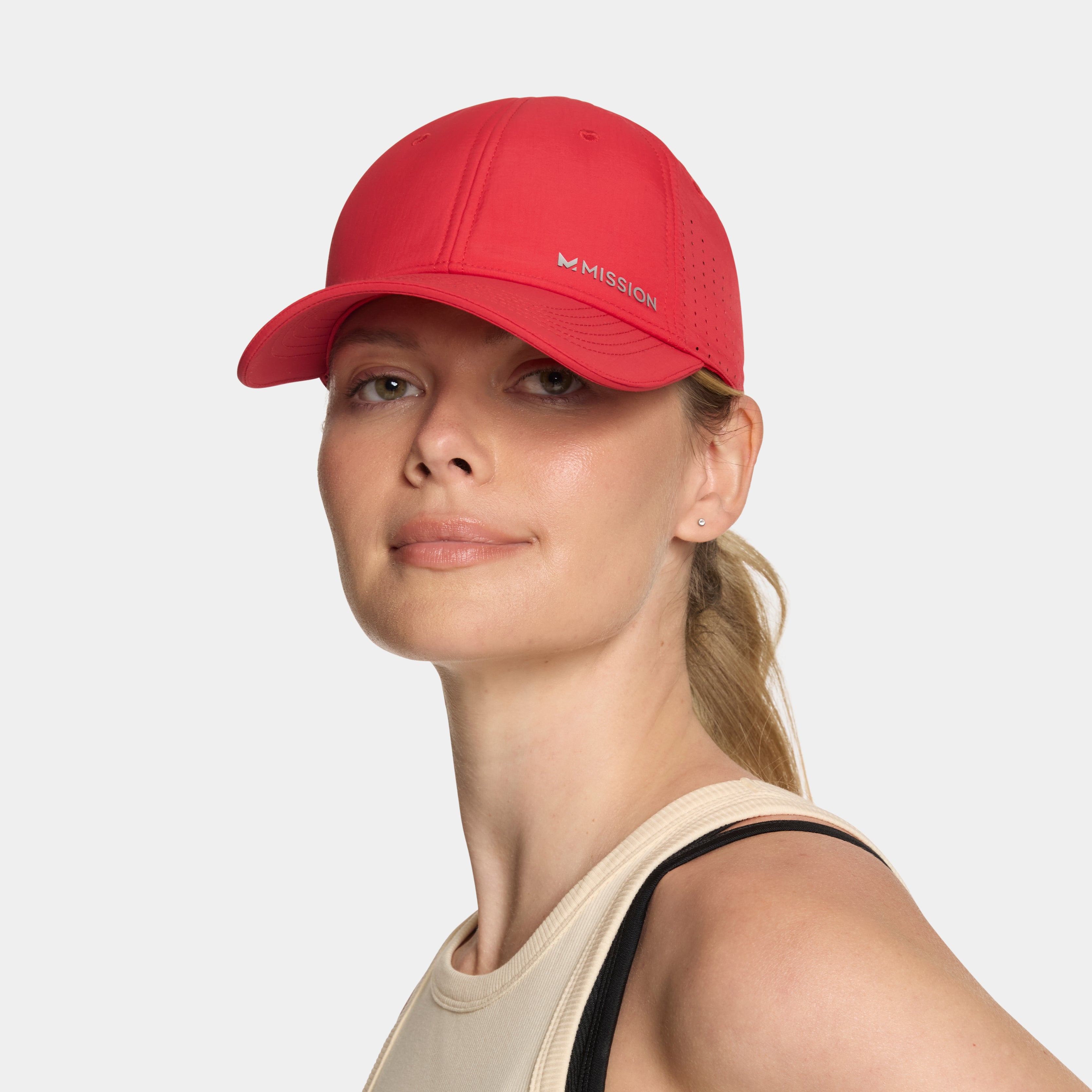 Woman wearing a red cap with 'Mission' branding on a white background