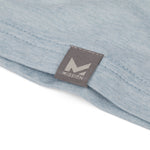 Close-up of a light blue fabric with a gray tag featuring the 'Mission' logo.