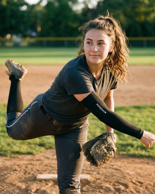 Woman in a softball uniform stretching on a field